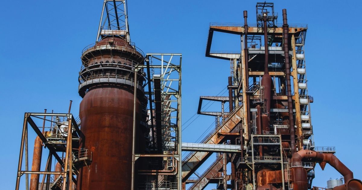 Heavily corroded industrial metal pipes showing rust and surface degradation